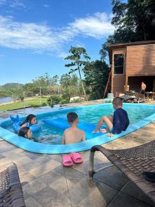 um grupo de crianças a brincar numa piscina em Refúgio vila das figueiras ! em Torres