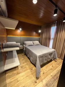 a bedroom with a large bed and a desk at Refúgio vila das figueiras ! in Torres