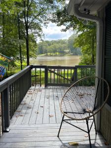 a chair on a porch with a view of a river at Heaven on Lake Sinclair in Resseaus Crossroads