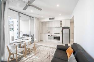 sala de estar con sofá, mesa y cocina en City Chic Living 1B1B Apt w/Shared Pool+BBQ+GYM, en Brisbane