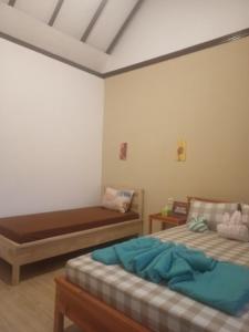 Un pat sau paturi într-o cameră la FAREL HOMESTAY KAWAHIJEN