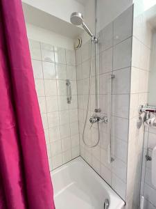 a bathroom with a shower with a pink shower curtain at neue Wohnung im Gebäude des Graf Eberhard Hotels in Bad Urach