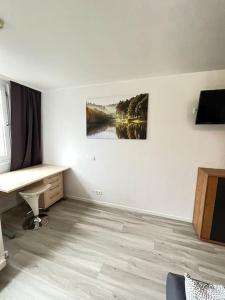 a room with a desk and a painting on the wall at neue Wohnung im Gebäude des Graf Eberhard Hotels in Bad Urach