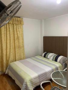 Un dormitorio con una cama y una mesa. en Huacachina Sunset, en Ica
