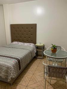 1 dormitorio con cama, mesa, mesa y silla en Huacachina Sunset, en Ica