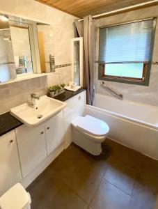 een badkamer met een wastafel, een toilet en een bad bij Beech Lodge 5 Hot Tub in York