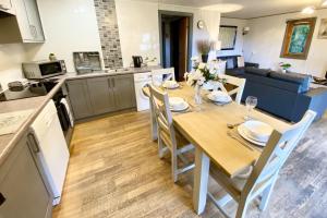 a kitchen and living room with a table and chairs at Beech Lodge 5 Hot Tub in York