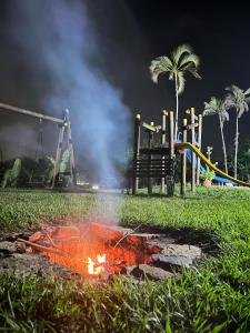 a fire laying in the grass next to a playground at Ventanas Parapente Boutique - Club House in El Cerrito