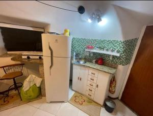 a small kitchen with a refrigerator and a table at Cabana Bela Vista in Búzios