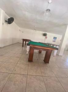 a ping pong table in a room with two tables at Cabana Bela Vista in Búzios