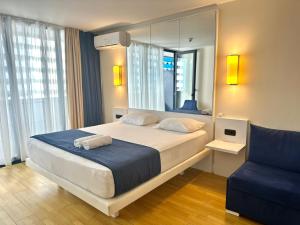 a bedroom with a large bed and a mirror at Queen apartments in batumi in Batumi