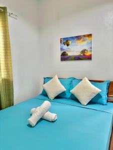 a blue bed with a stuffed animal on it at LUZVILLE Transient House - Port Barton in Itaytay