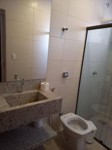 a bathroom with a toilet and a sink and a shower at Espaço aconchegante com wifi! in Patos de Minas
