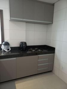 uma cozinha com um lavatório e uma bancada em Espaço aconchegante com wifi! em Patos de Minas