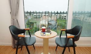 a table with two chairs and a table with two cups at Aurora Hotel in Jeju