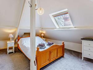 ein Schlafzimmer mit einem Holzbett und einem Fenster in der Unterkunft 3 bed property in Aldington 54088 in Dymchurch