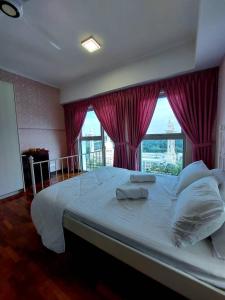 ein großes Bett in einem Zimmer mit einem großen Fenster in der Unterkunft Suria Homes in Shah Alam