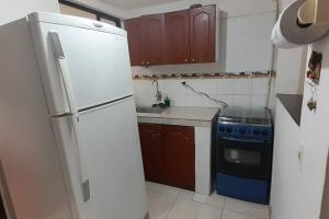 cocina con nevera blanca y fogones en Casa Blanca, en Ibagué