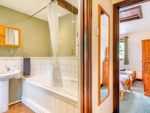 a bathroom with a tub and a sink at 2 Bed in Great Torrington 93053 in Little Torrington