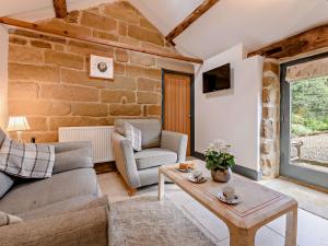 a living room with a couch and a table at 1 Bed in Helmsley 93100 in Chop Gate