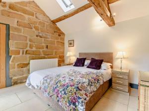 a bedroom with a bed and a stone wall at 1 Bed in Helmsley 93100 in Chop Gate