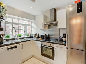 a kitchen with white cabinets and a stainless steel refrigerator at 2 Bed in Warwick 93085 in Warwick