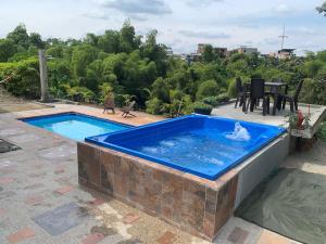 蒙特內格羅的住宿－Casa campestre Montenegro Quindio，一个带桌椅的大型蓝色游泳池