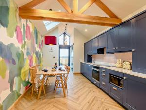 a kitchen with blue cabinets and a wooden table at 1 Bed in Lockerbie 93110 in Lockerbie