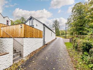 a road with a white building and a fence at 1 Bed in Lockerbie 93110 in Lockerbie