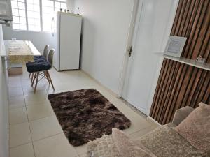 ein Wohnzimmer mit einem Kühlschrank und einem Tisch in der Unterkunft Apto novo, mobiliado e acochegante in Boa Vista
