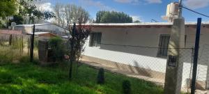 una recinzione di fronte a un edificio bianco di Departamento JERONIMO a Las Heras