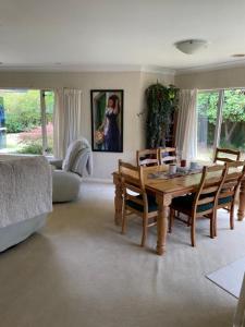a living room with a wooden table and chairs at Spacious Home in Paraparaumu