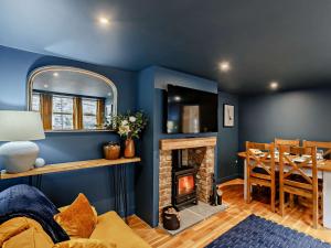 a living room with blue walls and a fireplace at 2 Bed in Leyburn 93162 in Leyburn