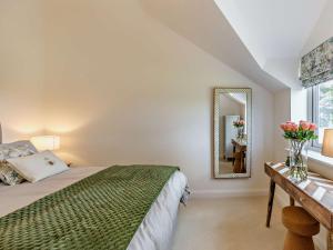 Schlafzimmer mit einem Bett und einem Tisch mit einem Spiegel in der Unterkunft 1 Bed in Melton Mowbray 93068 
