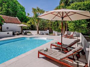 a pool with two lounge chairs and an umbrella at 2 Bed in Minehead 90925 in Minehead