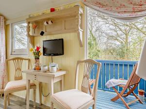 een veranda met een tafel en stoelen en een tv bij 1 Bed in Bodmin Moor 91964 in South Petherwin