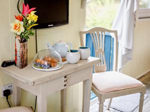 uma mesa com um prato de comida e um vaso de flores em 1 Bed in Bodmin Moor 91964 em South Petherwin