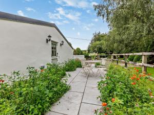 a patio with a table and chairs and flowers at 2 Bed in Barnstaple 5mls N 93023 in Chapelton