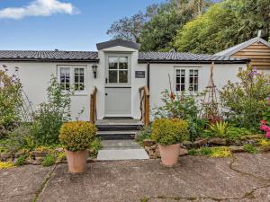 una casa con una puerta blanca y algunas plantas en 2 Bed in Barnstaple 5mls N 93025, en Chapelton