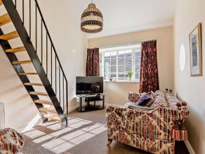 a living room with a staircase and a couch at 1 Bed in Bingley 91492 in Wilsden