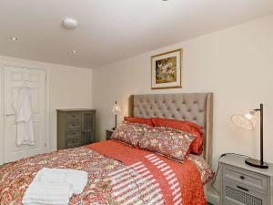 um quarto com uma cama grande e um cobertor vermelho em 1 Bed in Bingley 91492 em Wilsden