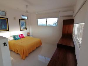 Schlafzimmer mit einem Bett und einem Fenster in der Unterkunft Amarilla (Amar y ya) in Cuatunalco