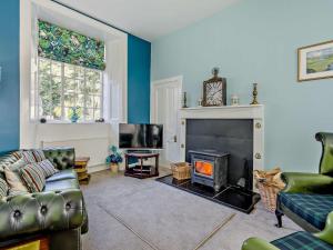 a living room with a couch and a fireplace at 2 Bed in Glen Clova 93001 in Kirriemuir