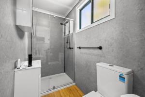 a bathroom with a shower and a toilet and a window at Eureka Stockade Holiday Park in Ballarat