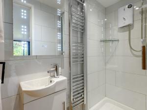 a white bathroom with a sink and a shower at 1 Bed in Highcliffe 90444 in Highcliffe