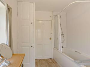 a bathroom with a tub and a sink and a mirror at 1 Bed in Bingley 91491 in Wilsden