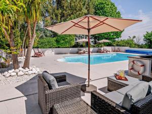 a patio with an umbrella and chairs and a pool at 1 Bed in Minehead 90923 in Minehead