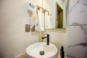 lavabo blanco en el baño con espejo en LOFT ALATORRE, en Guadalajara