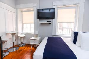 a bedroom with a bed and a flat screen tv at Charming & Stylish Studio on Beacon Hill #12 in Boston