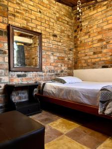 a brick walled bedroom with a bed and a mirror at Ventanas Parapente Boutique - Club House in El Cerrito